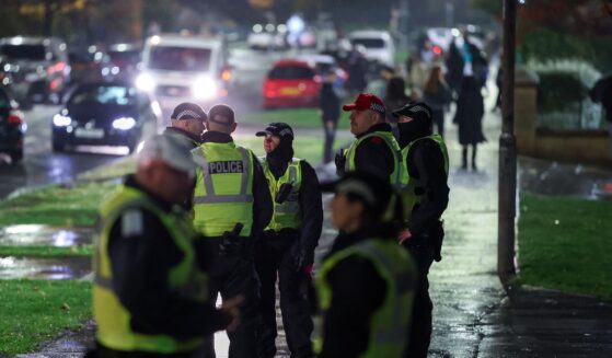 Police officers patrol the street as fireworks go off in the distance on Nov. 5, 2025, in Edinburgh, Scotland.