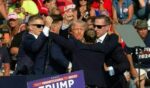 President Donald Trump is seen with blood on his face surrounded by Secret Service agents as he is taken off the stage at a campaign event at Butler Farm Show Inc. in Butler, Pennsylvania, on July 13, 2024.
