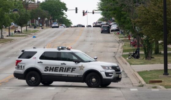 Law enforcement officers patrol the scene of the Fourth of July parade shooting in Highland Park, Illinois, on July 4, 2022.