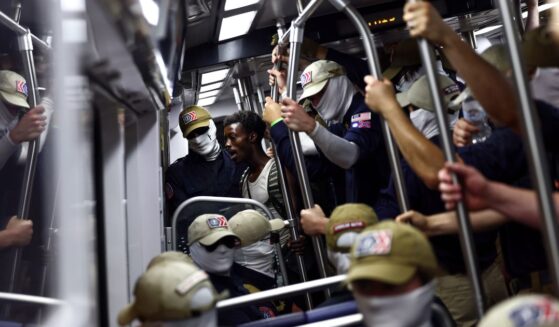 A passenger looks on as members of the white supremacist group Patriot Front ride the Washington Metro on July 4, 2026, in Washington, D.C.
