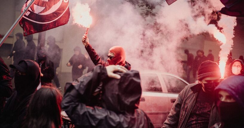 A person is holding a red smoke bomb during an anti-fascist demonstration held to mark the 13th anniversary of the death in 2013 of activist Clement Meric in Paris, France, on June 6, 2026.
