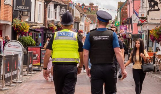 A policeman and a police community support officer walking down a busy street in Canterbury, Kent, United Kingdom, on Aug. 7, 2021.