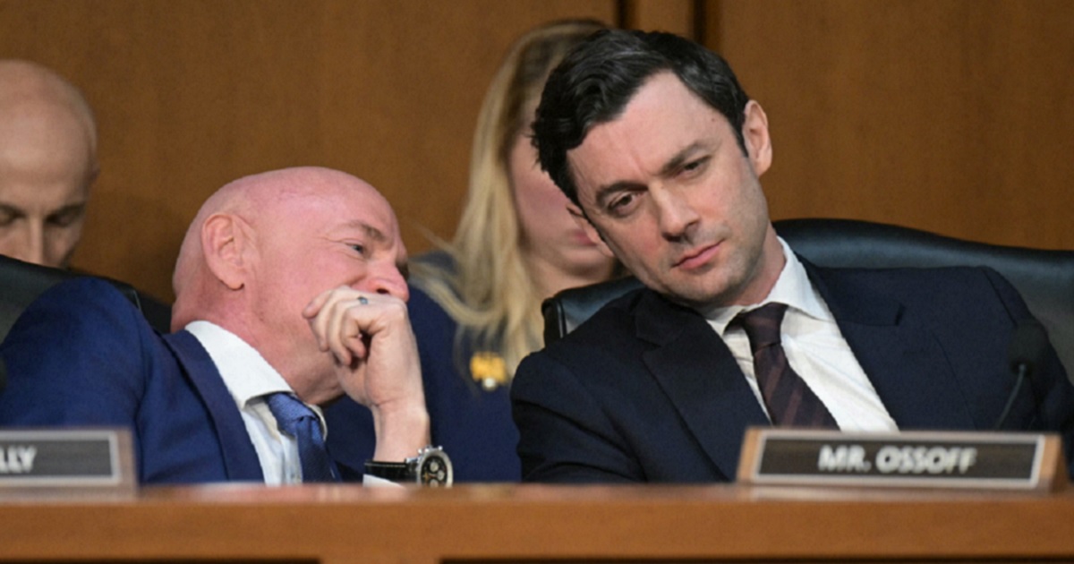 Democratic U.S. Sen. Jon Ossoff of Georgia, right, listens as Sen. Mark Kelly of Arizona whispers to him during a Senate March hearing.