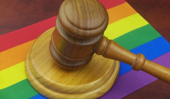 A judge's gavel on a rainbow flag.