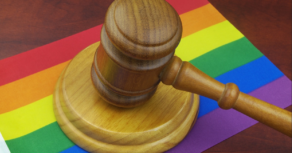 A judge's gavel on a rainbow flag.