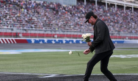 NASCAR Hall of Famer Kurt Busch lays white roses on the "8" stenciled of the infield grass during the remembrance ceremony for his brother, Kyle Busch, who passed away suddenly at the age of 41, prior to the NASCAR Cup Series Coca-Cola 600 at Charlotte Motor Speedway on May 24, 2026, in Concord, North Carolina.