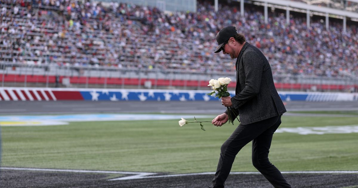 NASCAR Hall of Famer Kurt Busch lays white roses on the "8" stenciled of the infield grass during the remembrance ceremony for his brother, Kyle Busch, who passed away suddenly at the age of 41, prior to the NASCAR Cup Series Coca-Cola 600 at Charlotte Motor Speedway on May 24, 2026, in Concord, North Carolina.