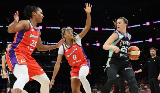 Sabrina Ionescu of the New York Liberty handles the ball against Alyssa Thomas and Monique Akoa Makani of the Phoenix Mercury during the first half of the WNBA game at Mortgage Matchup Center on Aug. 1, 2026, in Phoenix, Arizona.