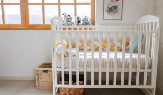 A baby crib in a modern cozy bedroom.