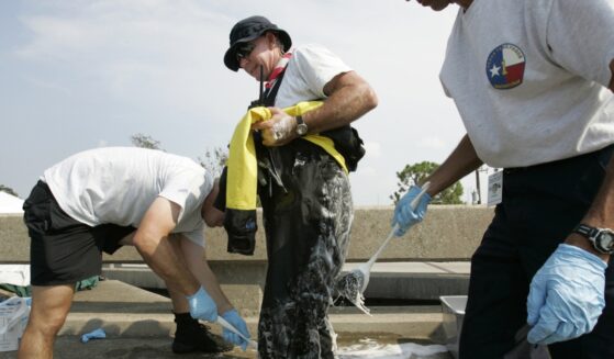Eddie Mathison of the Texas Task Force 1 Water Search and Rescue Team from Houston, Texas, is scrubbed down with bleach and soap after a day of running boat rescues throughout downtown New Orleans in the aftermath of Hurricane Katrina, on Sept. 5, 2005.