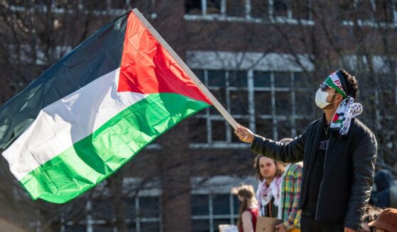 A person waves a Palestinian flag as pro-Palestinian protesters gather at an encampment set up at Northeastern University in Boston, Massachusetts, on April 25, 2024.