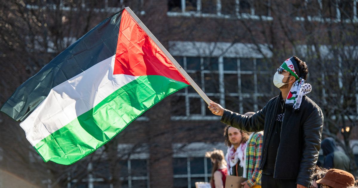 A person waves a Palestinian flag as pro-Palestinian protesters gather at an encampment set up at Northeastern University in Boston, Massachusetts, on April 25, 2024.