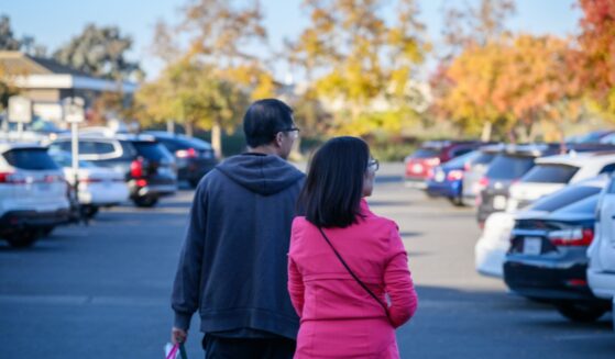 A couple carrying a shopping bag in the autumn.