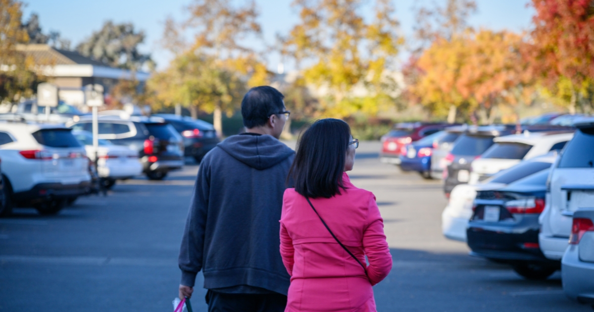 A couple carrying a shopping bag in the autumn.