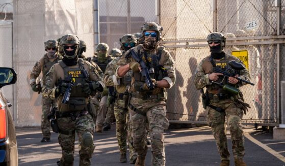 Immigration and Customs Enforcement agents run out of Delaney Hall Immigration Detention Center as they protect vehicles during a shift change on June 7, 2026, in Newark, New Jersey.