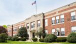 The exterior view of a typical American school building seen on a spring day.