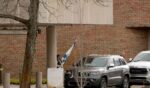 A person carries a flag of Israel from Temple Israel synagogue in West Bloomfield, Michigan, on March 13, 2026, after a person drove a vehicle into the synagogue a day earlier.