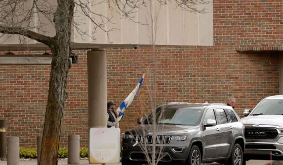 A person carries a flag of Israel from Temple Israel synagogue in West Bloomfield, Michigan, on March 13, 2026, after a person drove a vehicle into the synagogue a day earlier.