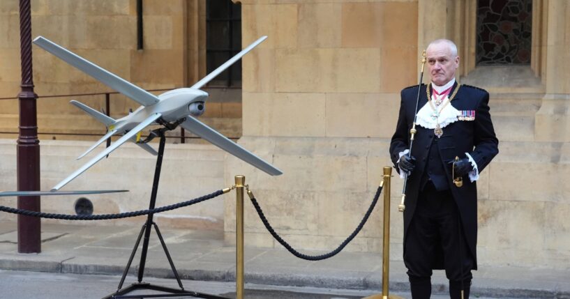 Gentleman Usher of the Black Rod, Lieutenant General Ed Davis, stands by a drone in Speaker's Square in central London on March 17, 2026, during a visit to the Palace of Westminster, home to Britain's Houses of Parliament, by Ukraine's President.