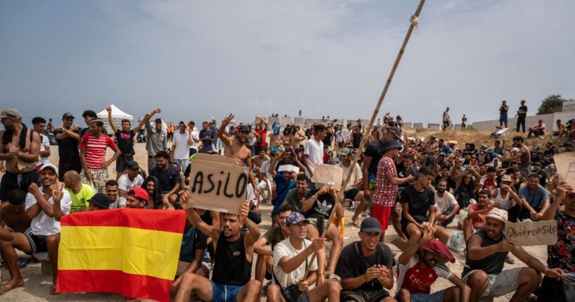 Migrants, mainly Moroccan, gather in a protest asking for asylum in El Trampolin beach on Aug. 16, 2026, in Ceuta, Spain.
