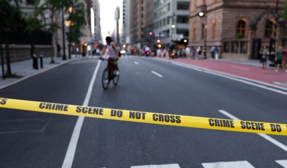 A cyclist is seen behind crime scene tape as police respond to a shooting incident in the Midtown Manhattan neighborhood of New York on July 28, 2025.