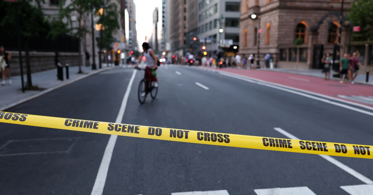 A cyclist is seen behind crime scene tape as police respond to a shooting incident in the Midtown Manhattan neighborhood of New York on July 28, 2025.