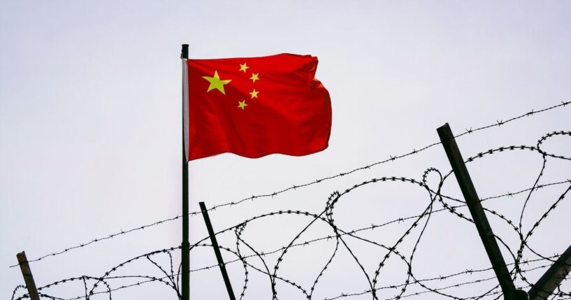 Prison bars with a Chinese flag.