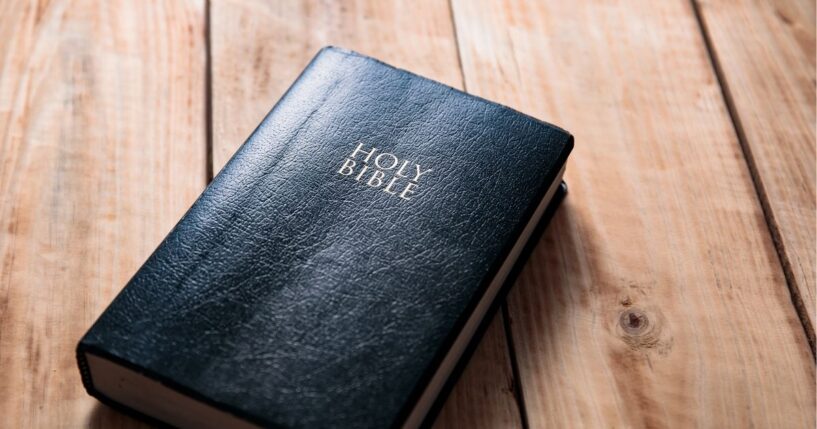 A Bible on a wooden table background.
