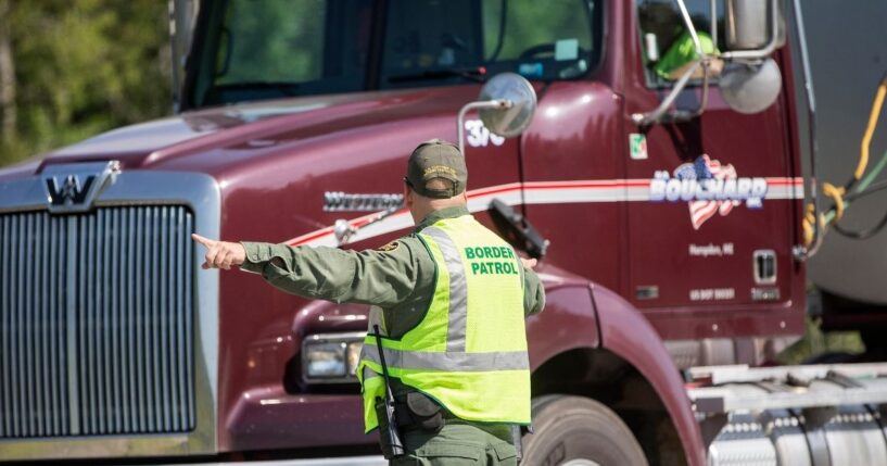 A U.S. Border Patrol agent directs vehicles as they enter a highway checkpoint on Aug. 1, 2018, in West Enfield, Maine.