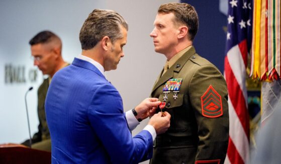 Secretary of War Pete Hegseth pins a medal on Marine Gunnery Sgt. Jonathan Eby, right, during a Pentagon event Wednesday to honor Marines who were serving during the 2021 Abbey Gate bombing in Kabul, Afghanistan.