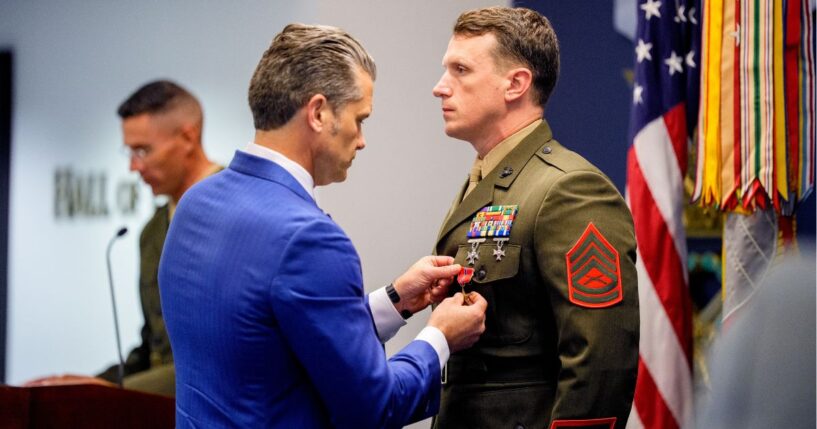 Secretary of War Pete Hegseth pins a medal on Marine Gunnery Sgt. Jonathan Eby, right, during a Pentagon event Wednesday to honor Marines who were serving during the 2021 Abbey Gate bombing in Kabul, Afghanistan.