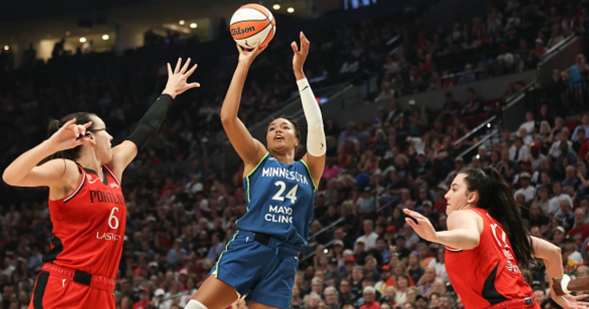 Napheesa Collier shoots a basketball as players surround her on the court in Portland, Oregon on August 12, 2026.