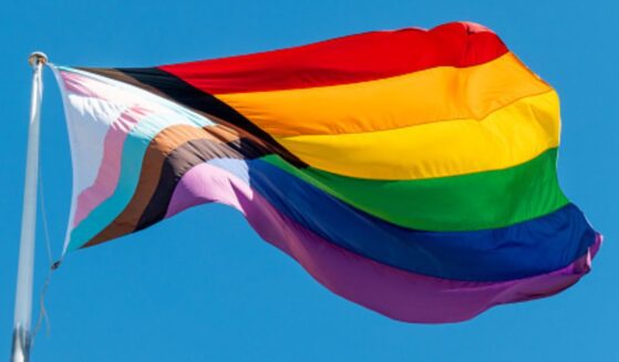 An LGBTQ flag flies in the sky.
