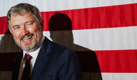 Former Rep. Thomas Massie smiles at crowd as he stands near an American flag on May 19, 2026.