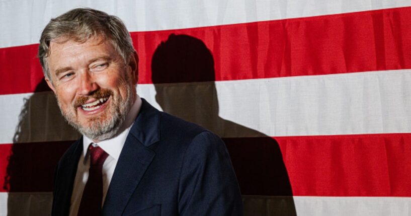 Former Rep. Thomas Massie smiles at crowd as he stands near an American flag on May 19, 2026.