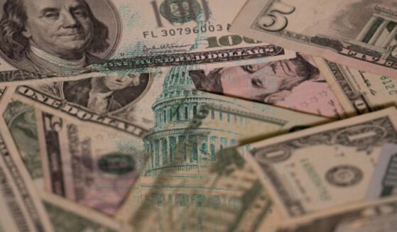 Dollar bills are pictured with an overlay of the United States Capitol Building.