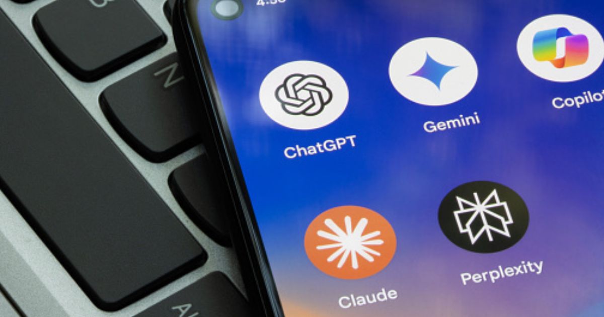 A phone screen displaying artificial intelligence apps lays on top of a laptop keyboard.