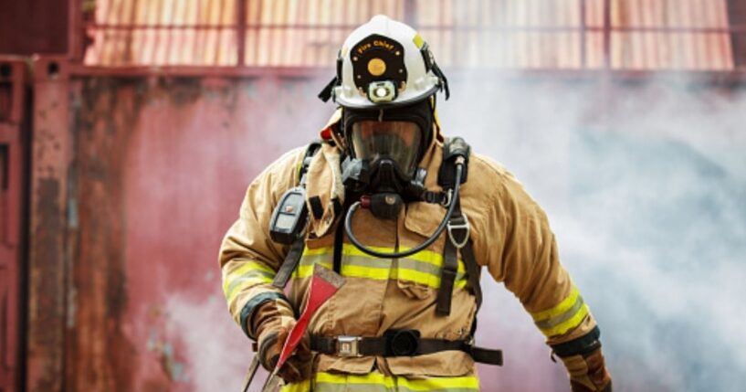 A firefighter walks away from a billow of smoke.