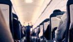 The interior of a plane as passengers sit in their seats.