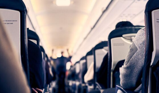 The interior of a plane as passengers sit in their seats.