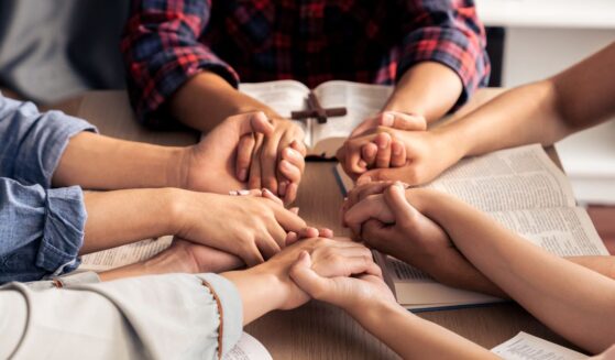 An image of young Christians holding hands and praying.