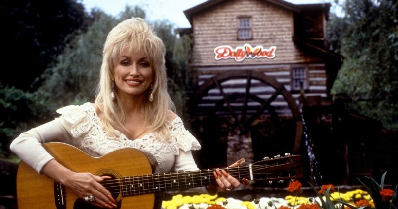 Dolly Parton holds her guitar outside of Dollywood in 1993 in Pigeon Forge, Tennessee.