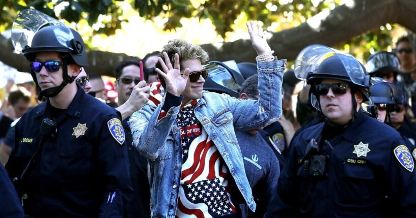Right-wing commentator Milo Yiannopoulos is escorted by police officers after appearing at a free-speech rally at U.C. Berkeley on Sept. 24, 2017, in Berkeley, California.