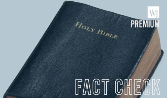 A well-read Holy Bible sits on a white surface.