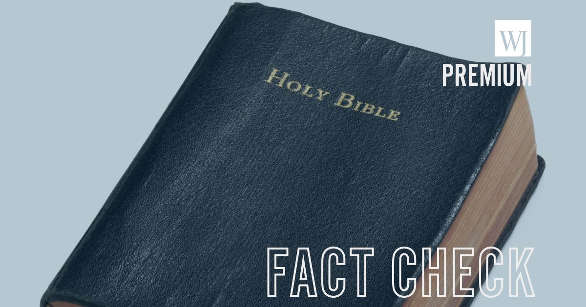 A well-read Holy Bible sits on a white surface.