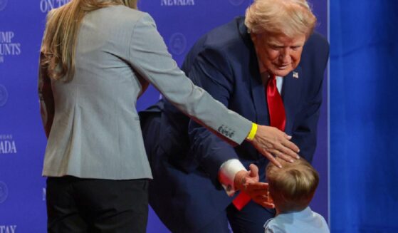 President Donald Trump greets a child onstage during an event at Red Rock Casino Resort and Spa on Wednesday in Las Vegas, moments before Trump turned on his grandfather switch.