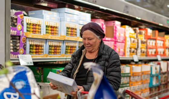 A woman checks a box of cookies while shopping at a Costco Wholesale store on April 13, 2024, in Colchester, Vermont.