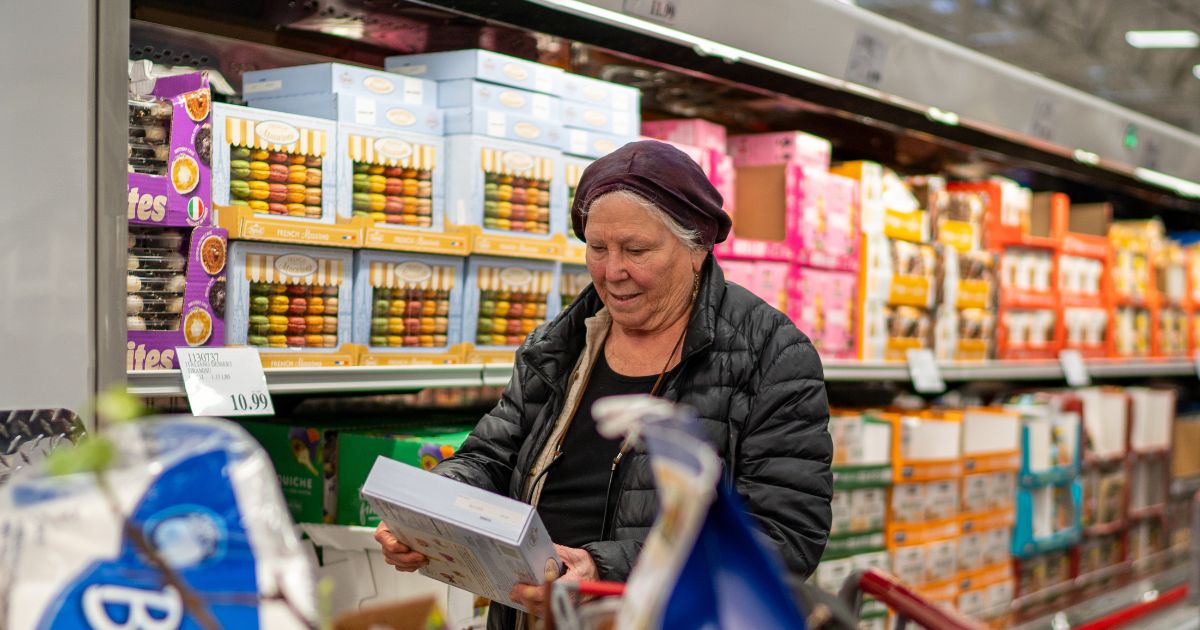 A woman checks a box of cookies while shopping at a Costco Wholesale store on April 13, 2024, in Colchester, Vermont.
