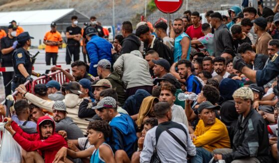 A large group of migrants crowd outside the entrance of the Loma del Colmenar reception center, waiting for admission, in Ceuta on Sept. 1, 2026.