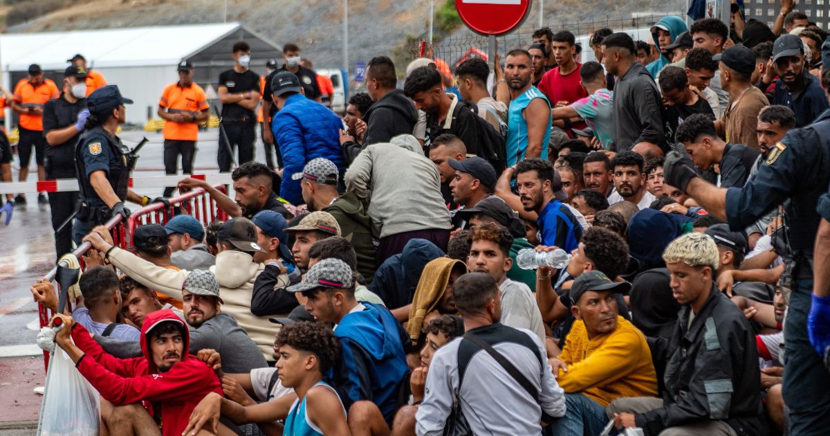 A large group of migrants crowd outside the entrance of the Loma del Colmenar reception center, waiting for admission, in Ceuta on Sept. 1, 2026.